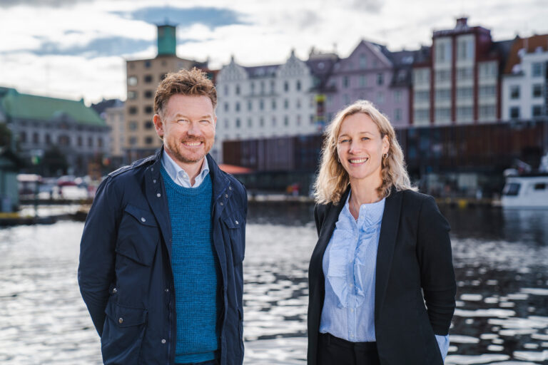 Two people looking into the camera smiling